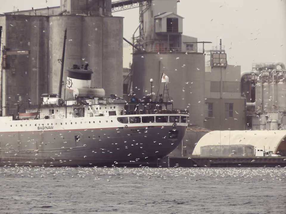 Frachtschiff im Hafen vor Silos und Kränen