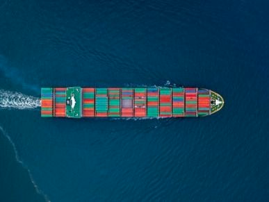 Containerschiff mit bunten Containern auf dem Meer, Luftaufnahme