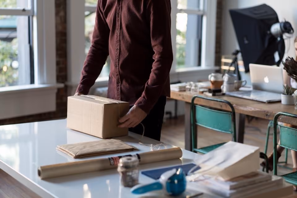 A person packing a product into a shipping box